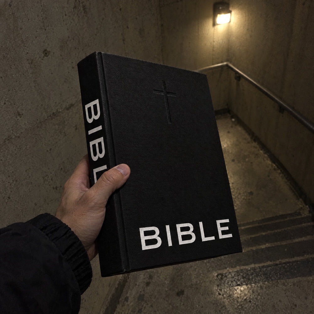 BIBLE held by the spine in a stairwell